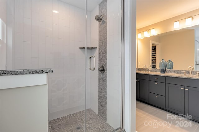 bathroom with tile patterned flooring, an enclosed shower, and vanity