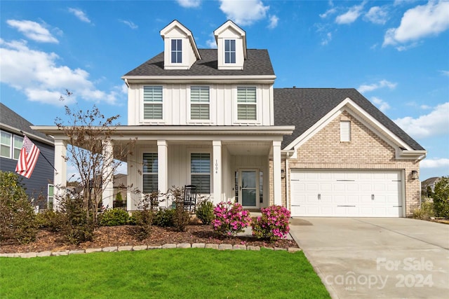 view of front of home featuring a garage, a porch, and a front lawn