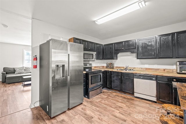 kitchen with light hardwood / wood-style flooring, stainless steel appliances, and sink