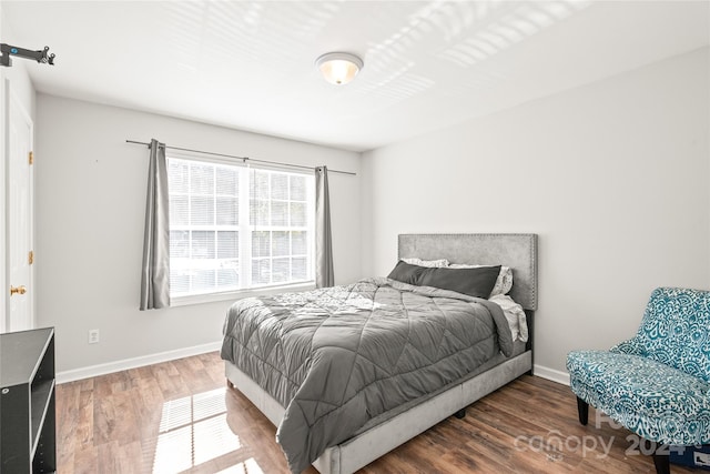 bedroom with dark hardwood / wood-style floors