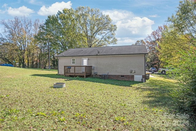 rear view of property with a wooden deck and a yard