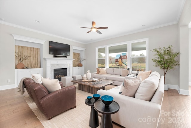 living room featuring light hardwood / wood-style floors, crown molding, and a high end fireplace