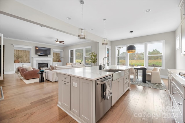 kitchen featuring dishwasher, white cabinetry, sink, and a kitchen island with sink