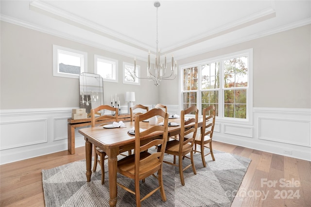 dining area featuring light wood-type flooring, a healthy amount of sunlight, and crown molding