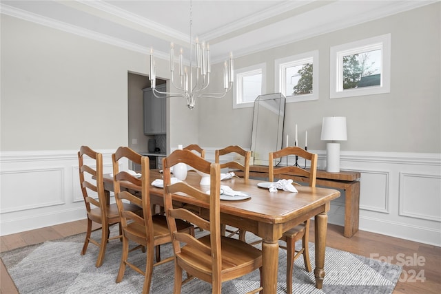 dining room featuring hardwood / wood-style flooring, crown molding, and an inviting chandelier