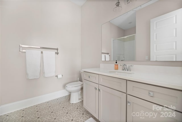 bathroom featuring vanity, a shower with shower door, tile patterned floors, and toilet