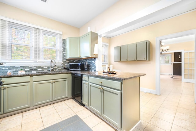 kitchen with green cabinets, light tile patterned floors, backsplash, and black dishwasher