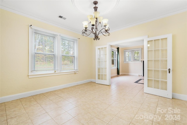 spare room with a chandelier, french doors, light tile patterned floors, and ornamental molding