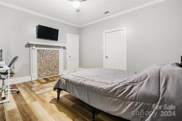 bedroom featuring hardwood / wood-style floors, ceiling fan, and crown molding