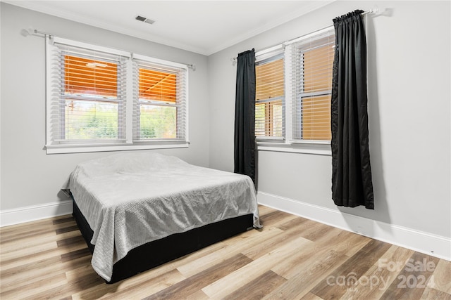 bedroom featuring wood-type flooring and crown molding