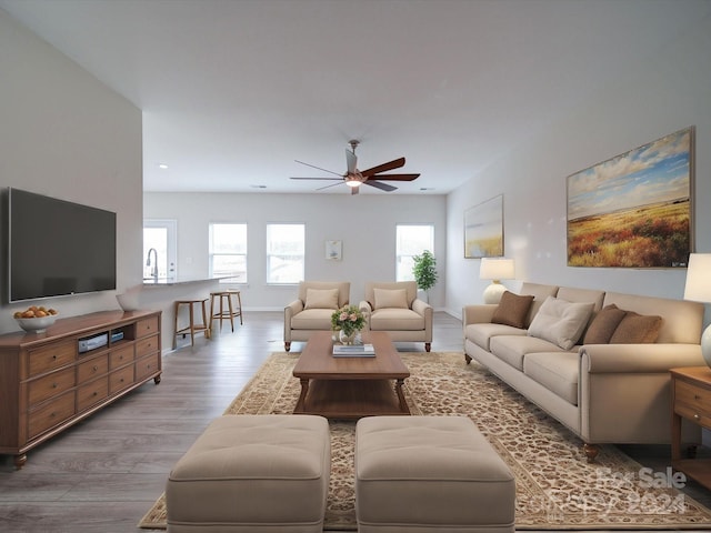 living room featuring light hardwood / wood-style floors and ceiling fan