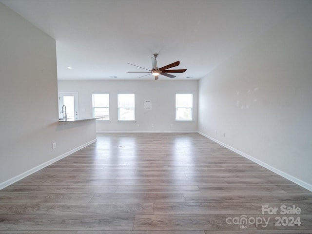 spare room featuring hardwood / wood-style floors, ceiling fan, and sink