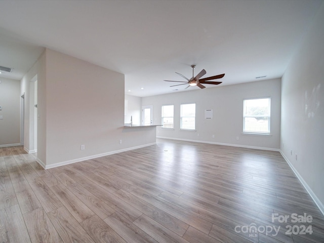 unfurnished living room with light wood-type flooring and ceiling fan