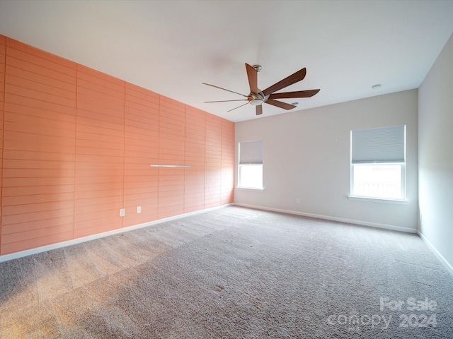 empty room featuring ceiling fan and carpet