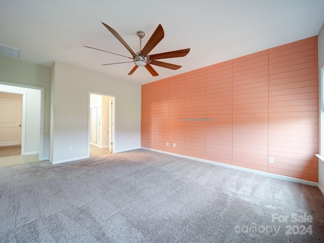 carpeted spare room featuring ceiling fan