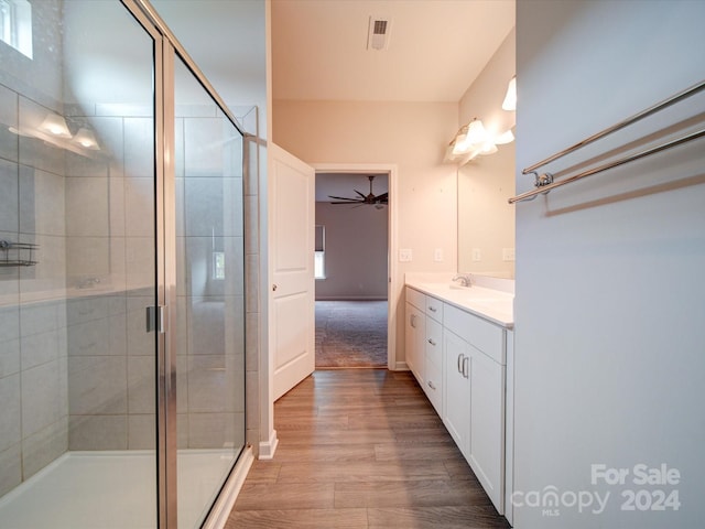 bathroom featuring a shower with door, vanity, hardwood / wood-style flooring, and ceiling fan