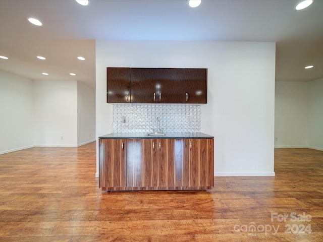 kitchen featuring hardwood / wood-style floors, sink, and decorative backsplash