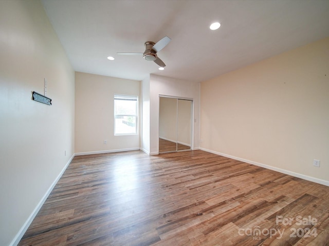 unfurnished bedroom featuring ceiling fan, a closet, and wood-type flooring