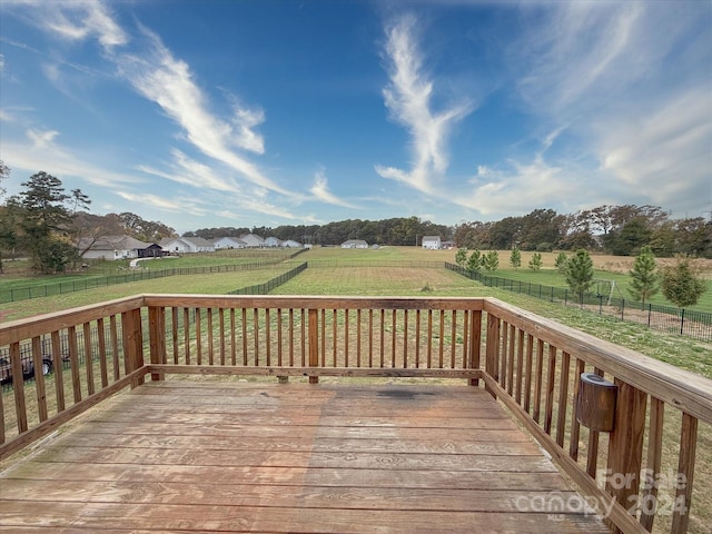 wooden terrace with a yard and a rural view