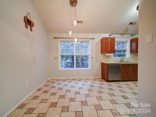 kitchen featuring a textured ceiling, sink, dishwasher, hanging light fixtures, and lofted ceiling