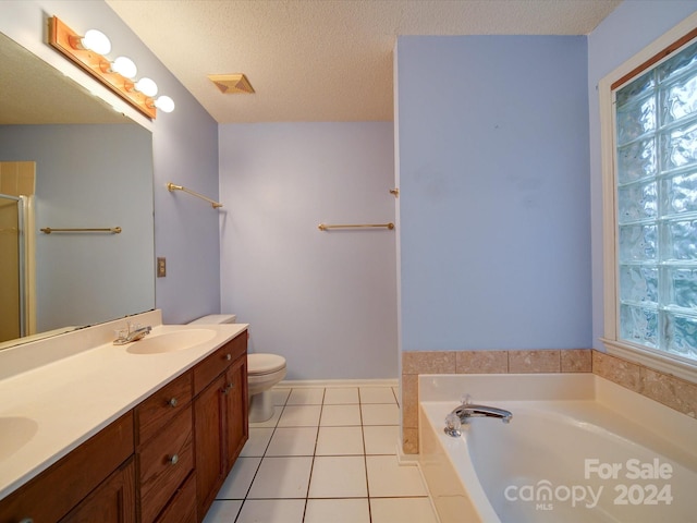 bathroom featuring a tub, tile patterned floors, a textured ceiling, toilet, and vanity