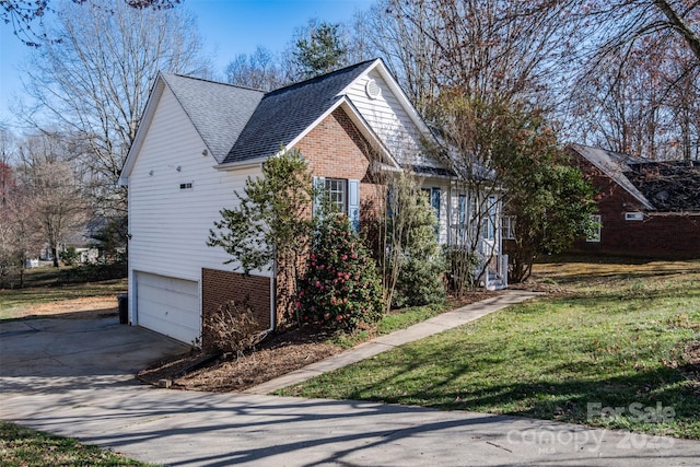 view of property exterior with an attached garage, a shingled roof, concrete driveway, a lawn, and brick siding