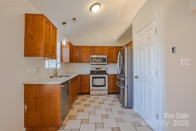 kitchen featuring brown cabinetry, visible vents, appliances with stainless steel finishes, and a sink