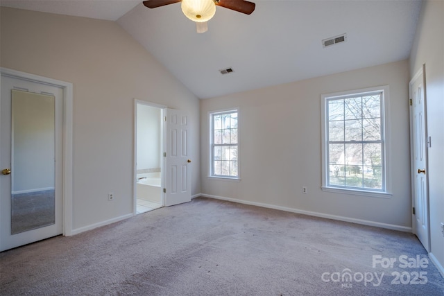 unfurnished bedroom with lofted ceiling, carpet flooring, baseboards, and visible vents