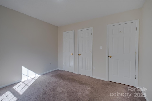 unfurnished bedroom with carpet flooring and baseboards