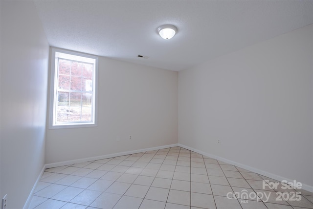 unfurnished room featuring a wealth of natural light, visible vents, and baseboards