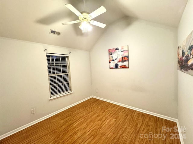 empty room with ceiling fan, lofted ceiling, and hardwood / wood-style flooring