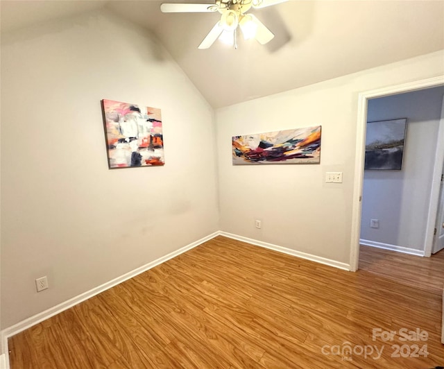 unfurnished room featuring hardwood / wood-style flooring, ceiling fan, and vaulted ceiling