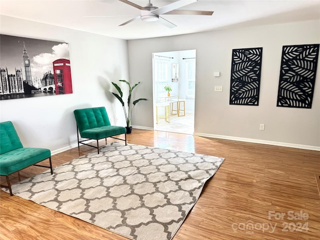 living area featuring hardwood / wood-style floors and ceiling fan