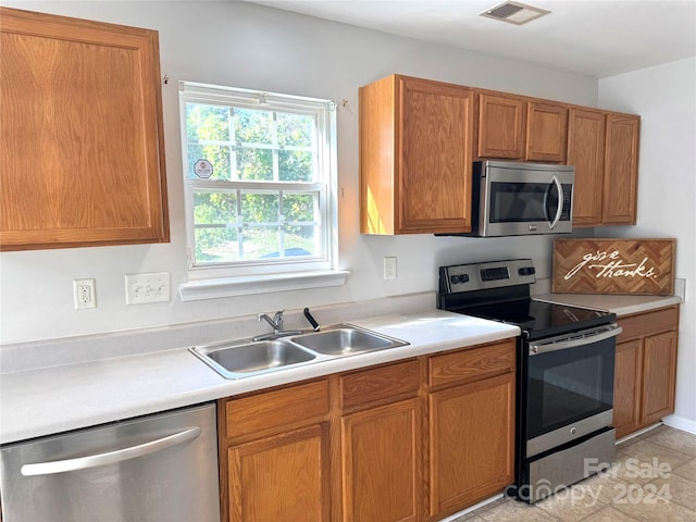 kitchen with light tile patterned floors, sink, and appliances with stainless steel finishes