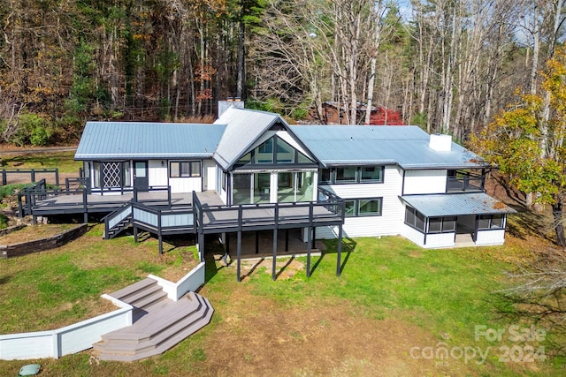 back of house featuring a sunroom, a yard, and a wooden deck