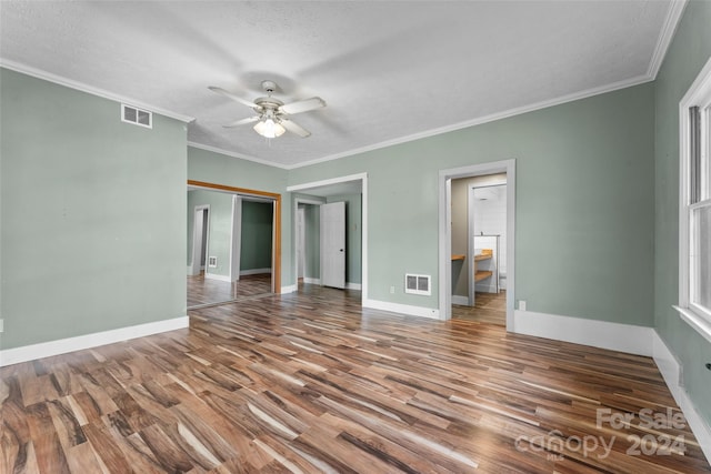 unfurnished bedroom with ornamental molding, a closet, hardwood / wood-style flooring, and ceiling fan