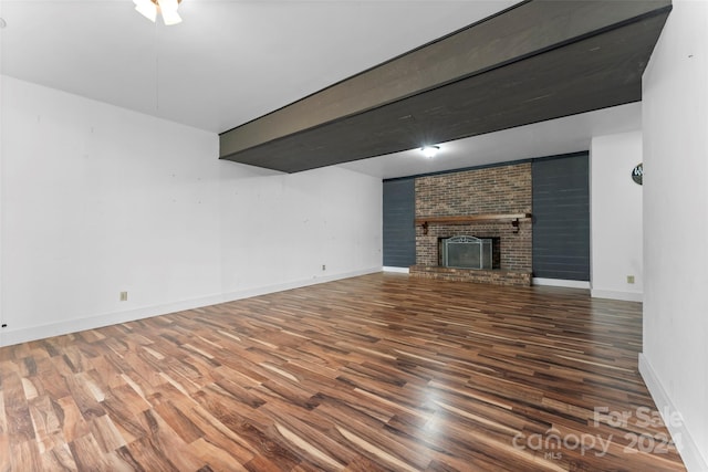 unfurnished living room featuring dark hardwood / wood-style floors and a brick fireplace