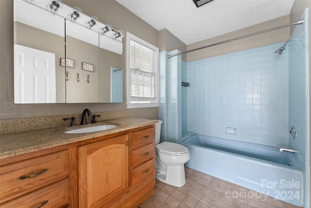 full bathroom featuring vanity, a textured ceiling, tiled shower / bath combo, tile patterned flooring, and toilet