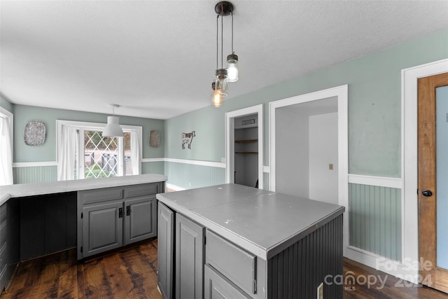 kitchen featuring dark hardwood / wood-style flooring, gray cabinetry, hanging light fixtures, and a center island