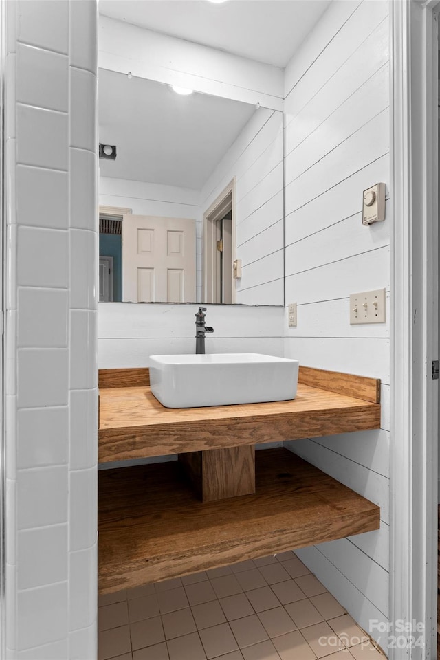 bathroom with vanity, wooden walls, and tile patterned flooring