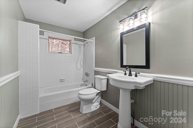 full bathroom featuring toilet, tiled shower / bath combo, and sink