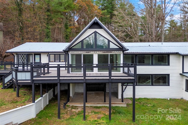 rear view of property featuring a patio and a wooden deck