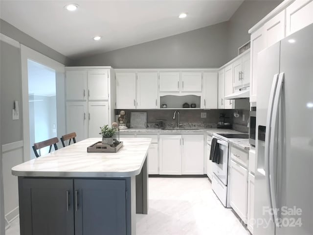 kitchen featuring lofted ceiling, fridge with ice dispenser, a kitchen island, electric range, and white cabinetry