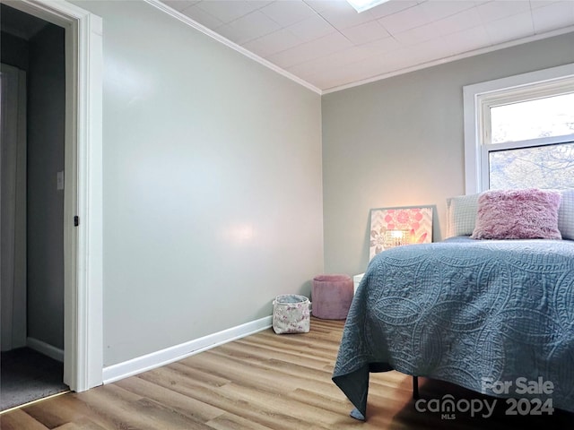 bedroom featuring wood-type flooring and ornamental molding