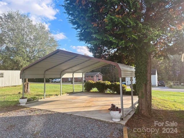 view of vehicle parking with a yard and a carport