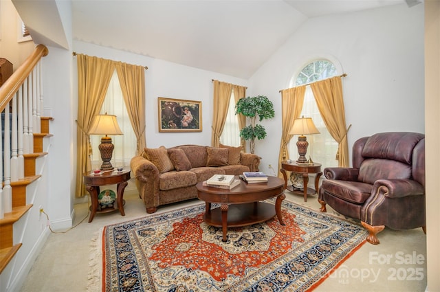 living area featuring lofted ceiling, a wealth of natural light, and carpet floors