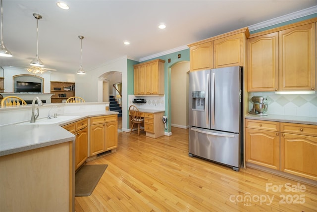 kitchen featuring stainless steel refrigerator with ice dispenser, light hardwood / wood-style flooring, backsplash, and hanging light fixtures