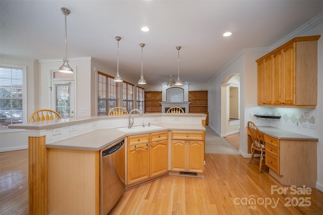 kitchen with stainless steel dishwasher, an island with sink, decorative light fixtures, and sink