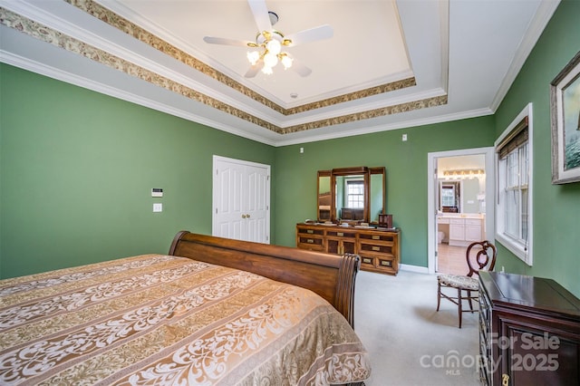 carpeted bedroom featuring ensuite bathroom, a closet, ornamental molding, and ceiling fan