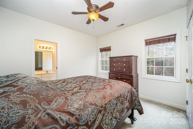 carpeted bedroom with ceiling fan and ensuite bath